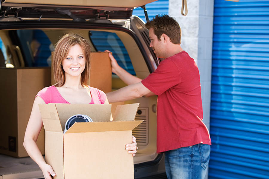 a man and woman moving boxes from a van to a storage unit in springfield illinois